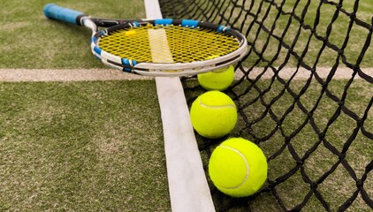 Tennis racket and ball on green background. Flat lay. Sports equipment