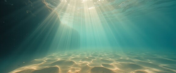 Sun rays shining underwater on sandy seabed creating ethereal and dreamy effect