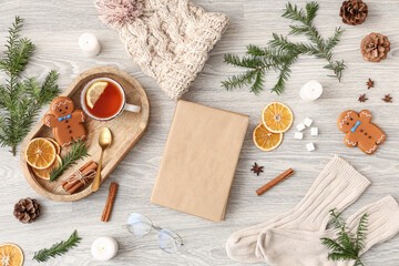 Composition with blank book, cup of tea, spices and burning candles on light wooden background