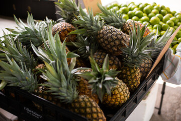stacked fresh pineapples at an outdoor market