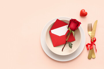 Beautiful table setting with red rose, heart and envelope on beige background. Valentine's Day celebration