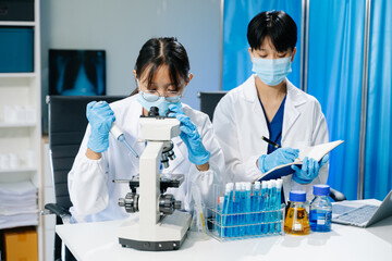 scientists in lab coats conducting research, handling glassware, and working with chemicals