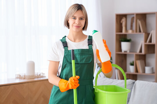 Beautiful young woman with mop and detergent at home - Powered by Adobe