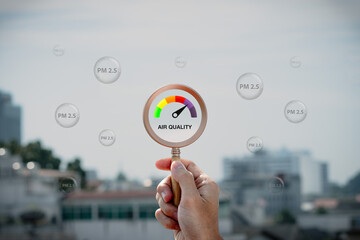 Hand holding a magnifying glass to check the air quality for PM 2.5 over smog city from PM2.5 dust on visibility city background with dangerous haze and fog. health care, pm 2.5 warning.