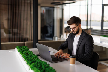 Businessman surfing net on laptop at l office