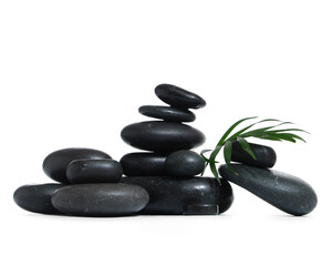 Fototapeta premium Stack of black spa stones and palm, leaf isolated on white background