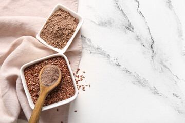 Bowls of flax seeds and flour on white background