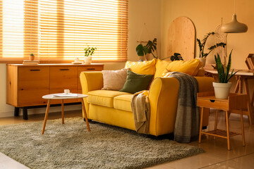 Interior of stylish room with comfortable yellow sofa and coffee table