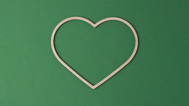 Cosmetic background with a wooden heart  on green. Flat lay, copy space