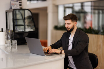 Portrait of a business man sitting in an office working on laptop