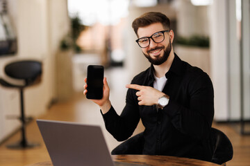 Business man pointing at his smart phone and showing a mobile banking app