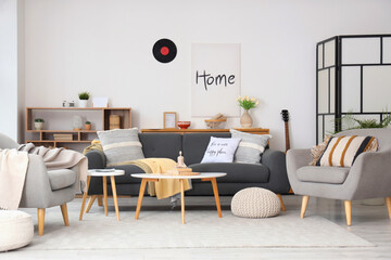 Interior of living room with black sofa, armchairs and folding screen