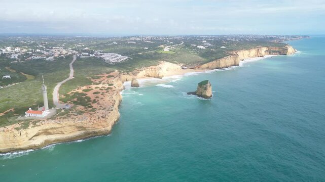Algarve coastline near ferragudo with lighthouse and sea cliffs, aerial view