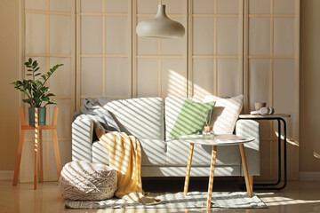 Interior of living room with folding screen, sofa and table