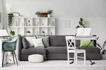 Interior of living room with synthesizer, sofa and plants