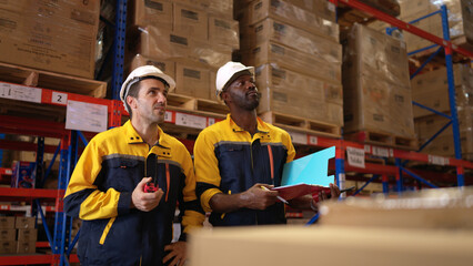 Two warehouse workers are reviewing the list of items based on the documentation