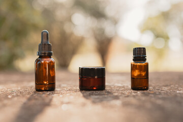 Minimalist collection of amber essential oil bottles outdoors in natural setting
