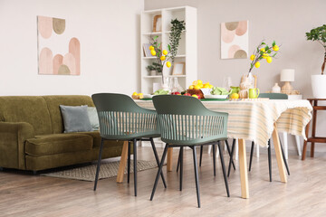 Interior of dining room with table setting, fresh citruses and lemon tree branches