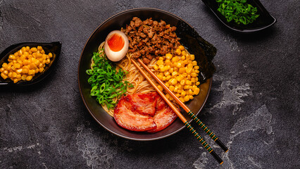 A bowl of ramen with noodles, meat and green onions.