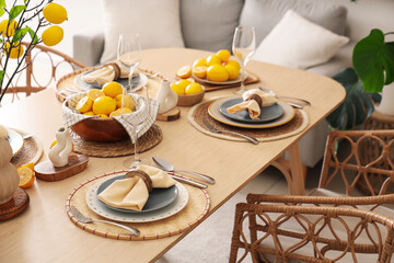Stylish table setting decorated with many fresh lemons in dining room