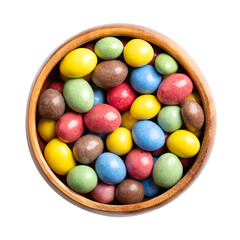 Candy coated milk chocolate peanuts in a wooden bowl. Roasted peanuts, coated with milk chocolate, with multi-colored sugar coating. Colorful sweet and treat. Close-up from above, isolated over white.