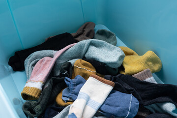 Men's and women's socks cluttered in storage boxes