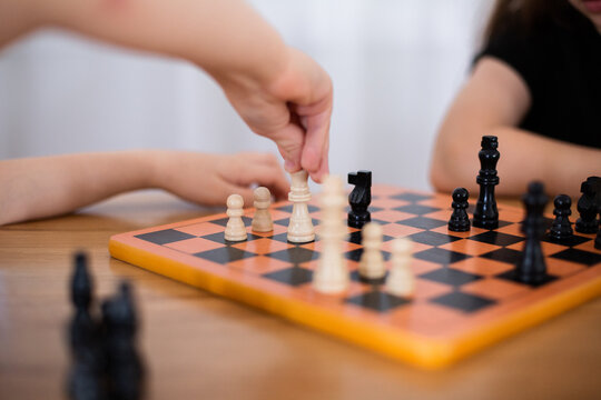 children learning to play chess and moving chess pieces