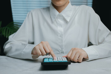 Business person using calculator in modern office setting, Business concept