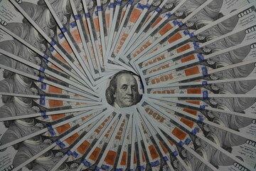 Obraz premium Circle made from american hundred dollar bills with an image of Benjamin Franklin in the center, top view, closeup