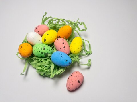 Small speckled multicolored eggs set close-up on a white background, isolated. Top view