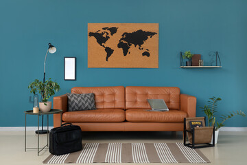 Interior of modern office with leather sofa, briefcase and coffee table near blue wall