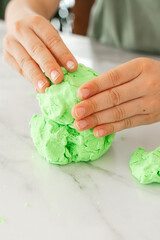 Hands Molding Green Dough on a Marble Surface