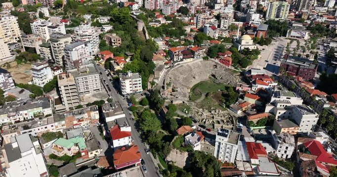 Aerial: amphitheatre of Durres in the city during the day in Albania, establishing drone shot
