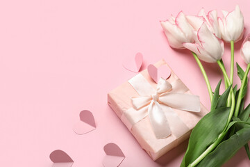 Beautiful tulip flowers with gift box and paper hearts on pink background. Mother's Day celebration
