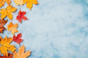 A beautiful display of autumn leaves in rich colors set against a soft blue background creating a seasonal contrast