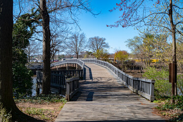 Wooden path and wooden footbridge with railings over the river.