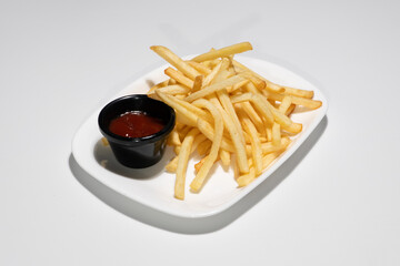 Golden Crispy French Fries Served on White Platter with Red Tomato Ketchup Sauce