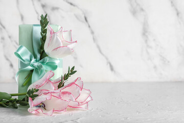 Beautiful tulip flowers with eucalyptus branches and gift box on white background. Mother's Day celebration