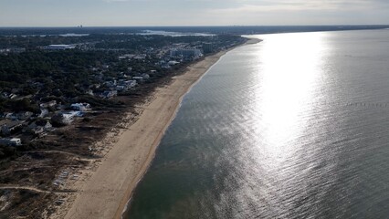 Virginia Beach, VA coastline at sunset with sandy beach and resorts with beach house by calm...