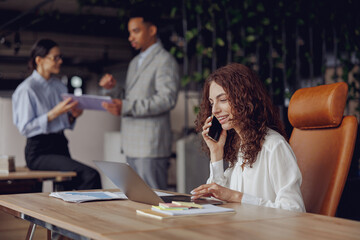 A diverse group of skilled professionals is collaborating effectively in a modern, welldesigned office setting