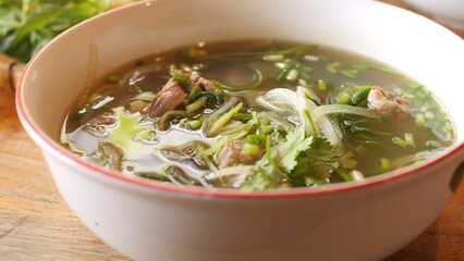 Vietnamese food hot pho with meat rich broth fresh herbs and bean sprouts Hot food is served on table ready to eat Traditional Asian food pleases with deep aromas spiciness and authentic taste