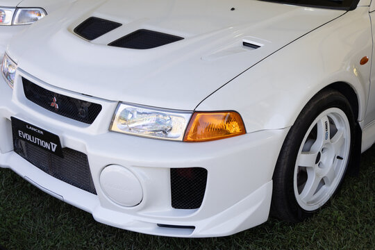 White mitsubishi lancer evolution v on grass, sporting a clean and powerful design