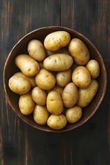 Overhead View of Fresh Yellow Potatoes in Wooden Bowl Rustic Dark Background