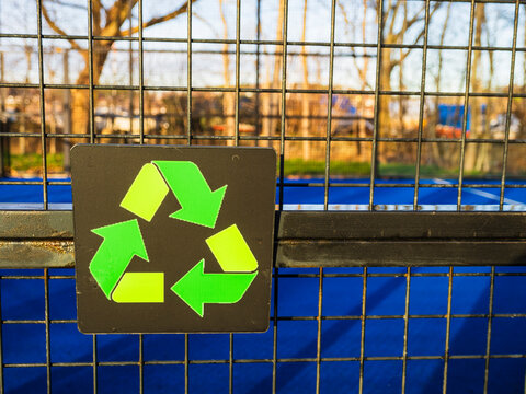 Recycle sign board mounted on fence