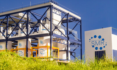 concept of a SMR small modular nuclear reactor power plant on a sunny day. SMR is a future energy concept. 3d rendering.