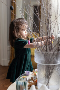 Little girl decorating dried plant for Easter