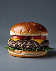 A charcoal grilled looking black bun burger on a plain deep gray background