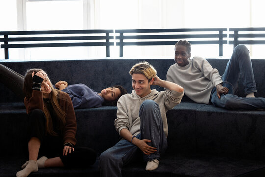 Male and female multiracial friends enjoying leisure time with each other at campus