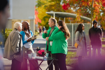 Male and female volunteers explaining about charity work to neighbors at park
