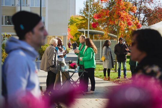 Male and female volunteers discussing about charity work with neighbors at park